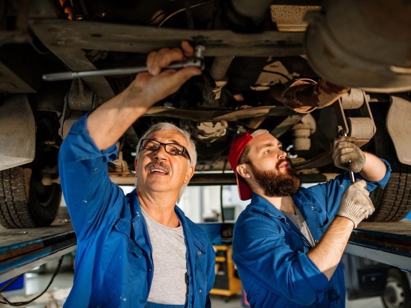 young-and-mature-technicians-of-car-repair-service-fixing-details-of-car-motor.jpg